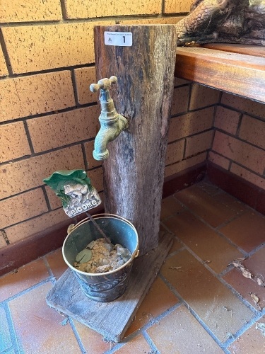 Tap on fence post with painted bucket for display