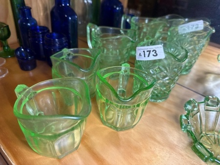 Assortment of green glass cream jugs