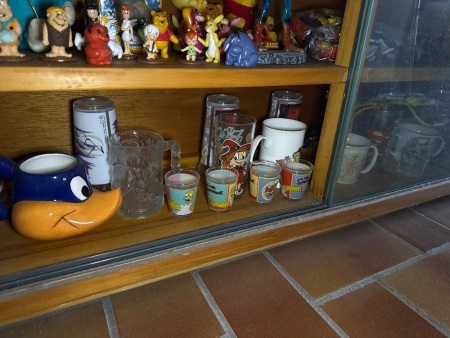 Shelf lot of Disney and comic character glasses cups, etc
