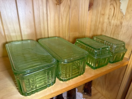 Four green glass butter dishes