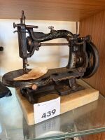 Unmarked sewing machine on marble base