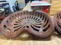 Two antique cast iron farm tractor seat