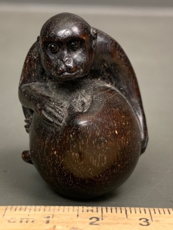 Vintage Japanese Carved Ebony Netsuke Depicting a Monkey on a Large Nut with Inset Eyes