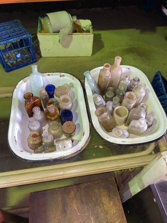 2 enamel trays of small antique bottles