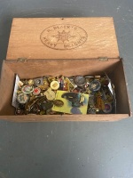 Old wooden cigar box with assortment of mixed badges