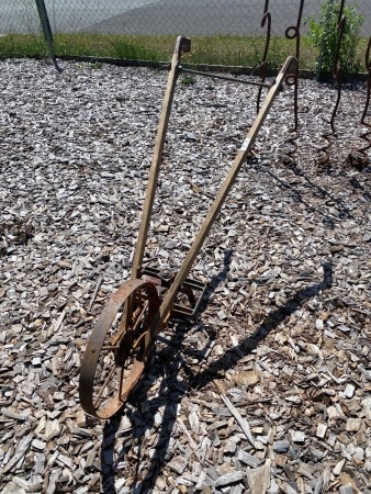 Vintage hand plow with wooden shafts and extra attachments