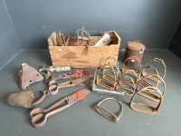 Wooden box with riding stirrups, hand shears and mixed metal items.