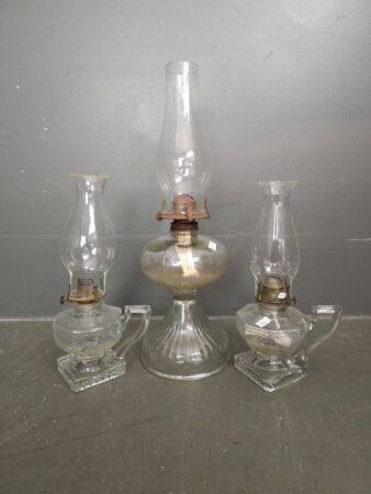 2 small clear glass lanterns with handles and one large clear glass lantern.