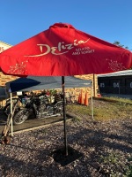 Large red patio umbrella in metal stand