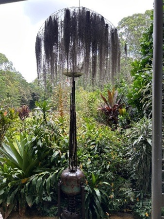 Metal art sculpture with hanging grass canopy