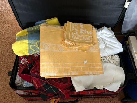 Red tartan suitcase full of linen - mostly table settings