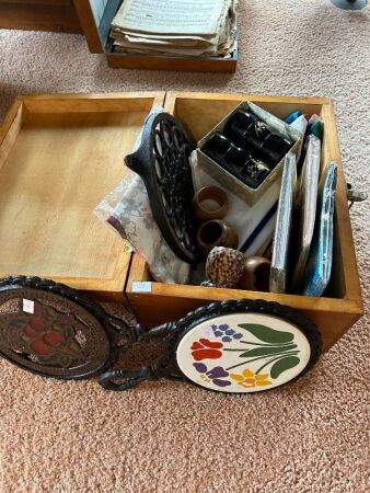 Box containing iron pot trivets, napkin rings etc