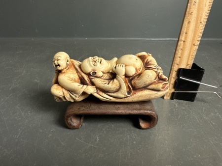 Vintage carved laughing lying down Buddha on wooden base