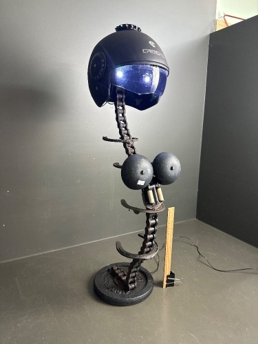 Abstract sculpture made from chain, helmet, weight, horseshoes etc - lights up