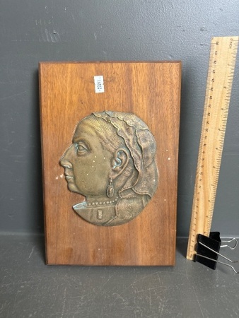 Vintage brass plaque of lady mounted on wood
